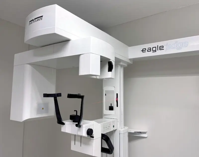 Aparelho branco de radiografia odontológica panorâmica instalado em sala clara